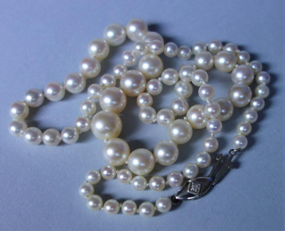 Vintage Cultured Pearl & Diamond Necklace: A fine vintage graduated single-strand cultured pearl necklace. The necklace is composed of 76 pearls, hand-knotted ranging in size as high as 9mm graduating down to 4mm. 14K white gold fish-hook clas
