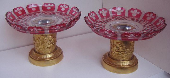 Baccarat Red Cut to Clear Tazzas on Bronze Stands: Pair of Baccarat red cut to clear tazzas, set in dore bronze stands with putti decoration (married pieces). Overall measurement: 9" in diameter and 6.5" high, unsigned.