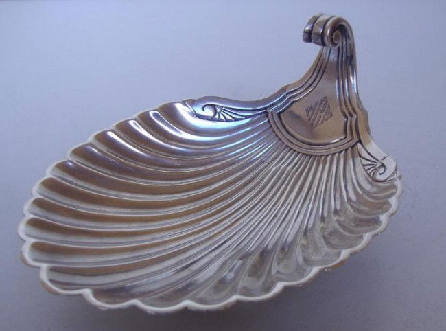Tiffany Sterling Shell-Formed Dish, c1920: Sterling shell-formed scalloped edge dish. Marks on the reverse include Tiffany & Co, 19790, Makers 15753, Sterling Silver, 925-1000 and the letter M for Charles Moore. The dish measures 6" x 4" and 2