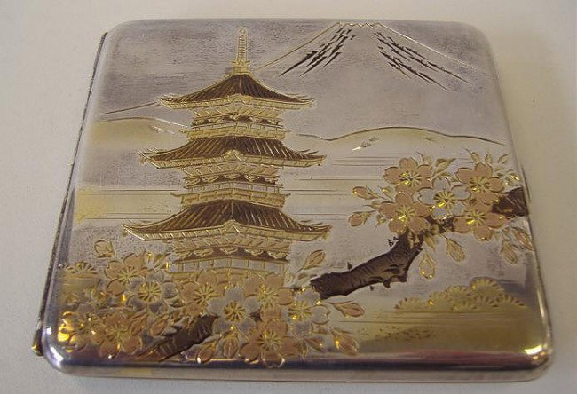 950 Silver & Mixed Metal Cigarette Case: Design on the front depicts a pagoda in a floral setting beneath Mount Fuji. Interior marked Silver 950. The backside of the case has a Japanese 3-Character mark. Measures 3.25" x 3".
