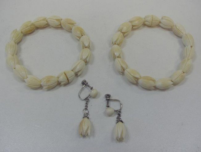 Two Carved Ivory Bracelets & Earrings: Each bead of the carved ivory bracelets depict a flower. There is one set of earrings with the same motif. The bracelets attach to each other to form a necklace.