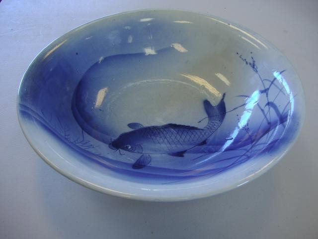 Japanese Koi Decorated Porcelain Bowl: Large blue and white porcelain bowl decorated with a swimming Koi. Measures 16" in diameter and 4" high. Signed with an impressed 4-character mark on the underside.