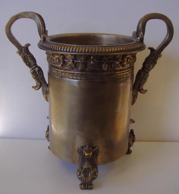 Bronzed-Metal Wine Champagne Cooler: Handled wine or champagne cooler. Well decorated with a band of grapes and leaves surrounding the top portion, gadrooned edging. Rests on three leaf -formed feet. Comes with a glass insert. Unsigned