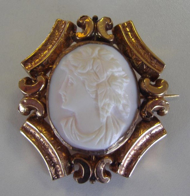 Victorian Carved Cameo Brooch set in 10K Gold: Well carved cameo profile set in an ornate 10K gold frame.