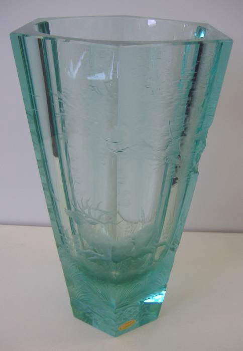 Moser Intaglio Cut Glass Vase, Stag Forest, R.W.: Six-sided green glass vase by Moser depicting a stag in a forest setting. The vase measures 9.25" tall and 5" in diameter. Signed Moser underfoot. Retains the original paper label. The vase is also in