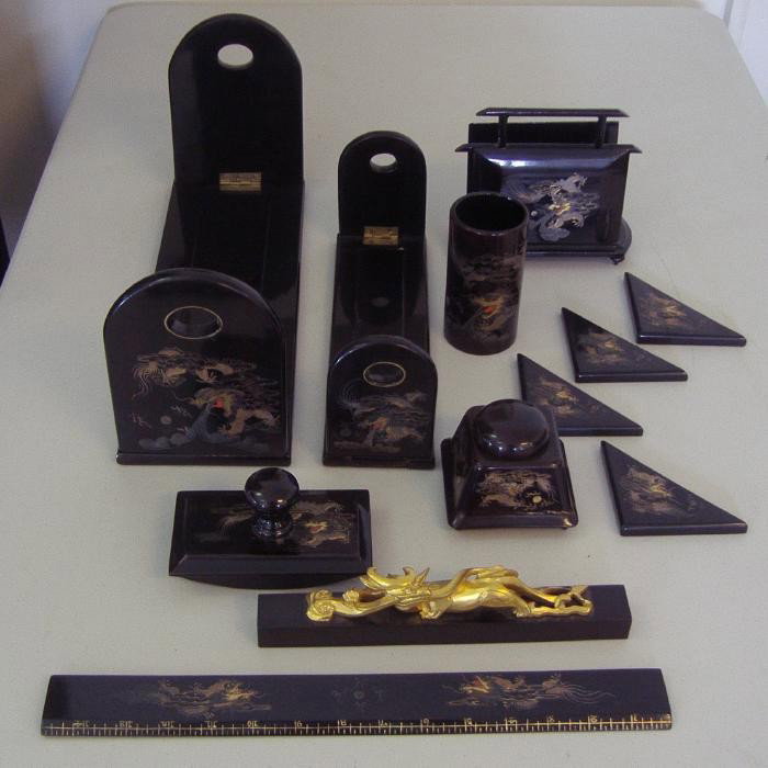 Chinese Foochow Lacquer Desk Set, 12 pieces: Fuzhou lacquer desk set consisting of two book holders, an inkwell, pen holder, ruler, blotter, letter holder, paper weight and 4 desk pad corners, each decorated with a dragon.