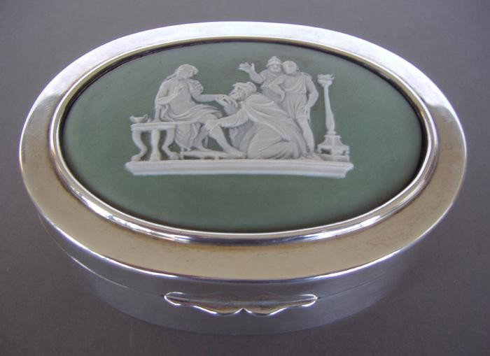 Sterling Trinket Box with Wedgwood Jasper Plaque: Sterling trinket box with an oval Wedgwood jasper ware plaque depicting a Greco-Roman scene. Hallmarks for London, 1904, with a Maker's mark of JB LW. The box measures 4" x 2-7/8" x 1.5".