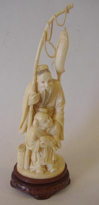 Chinese Carved Ivory Sculpture, Fisherman & Child: Well carved ivory sculpture depicting a fisherman and a child with their catch. The boy holds a fish while the elder has a fish on his line. Measurement on fitted wood stand, 10". NOTE: very minor los