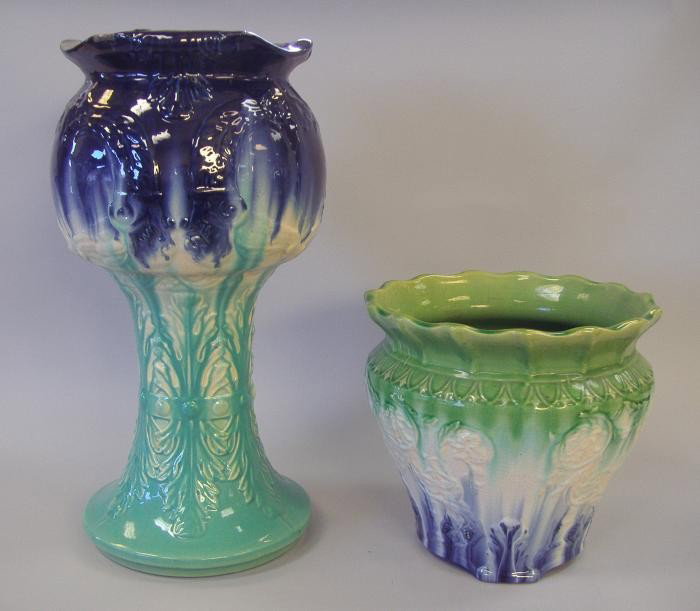 2 Majolica Jardinieres & Pedestal: Tall majolica jardiniere with attached stand measuring 18" tall, together with a jardiniere measuring 9" tall. NOTE: Chipping to rim of larger jardiniere and overall glaze crazing to both.