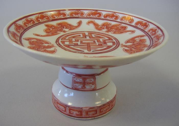 Chinese Porcelain & Enamel Tazza with Bats.: Chinese porcelain footed tazza decorated with over-glaze enamels depicting bats surrounding a Chinese symbol. Measures 4-1/8" in diameter and 2-3/8" high.