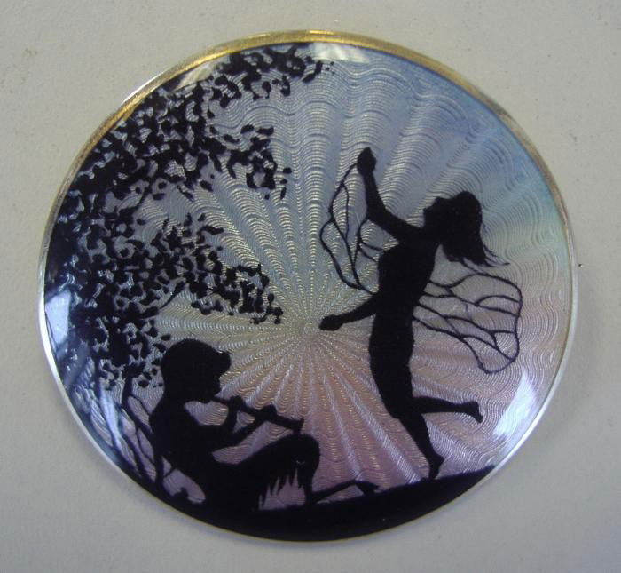 Marius Hammer 930 Silver Silhouette Enamel Brooch: Guilloche enamel brooch pin with a silhouette depicting Pan serenading a fairy in a garden setting. The back is signed with the Marius Hammer cipher and 930S. Measures 1.75" in diameter.