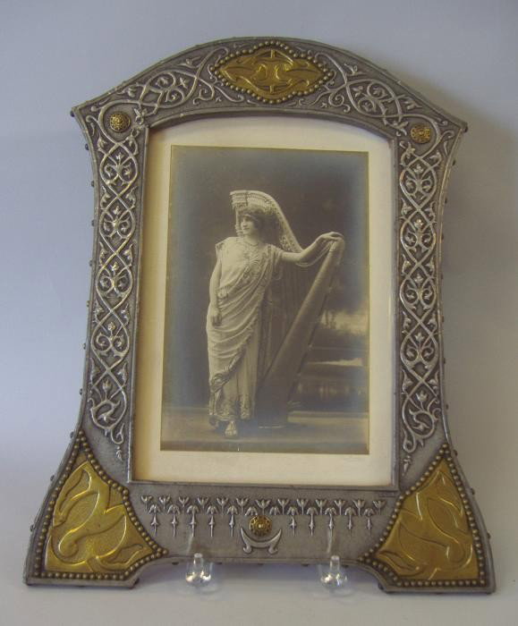 Art Nouveau Photo & Frame signed Renee: Embossed silvered metal and brass photo frame signed Renee. Overall measurement 18.5" x 14.5". The opening measures 12.25" x 8.25". (perfect frame for a mirror). The back stand is missing. Included is