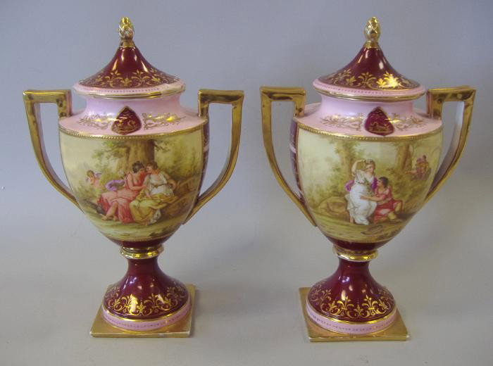 Pair of Royal Vienna Hand Painted Urns Artist Sgnd: Pair of hand-painted porcelain urns by Royal Vienna. Artist signed K.C. Meyer. The urns each measure approximately 12" high. Very good overall condition. No chips, cracks, hairlines or repairs. Blue b