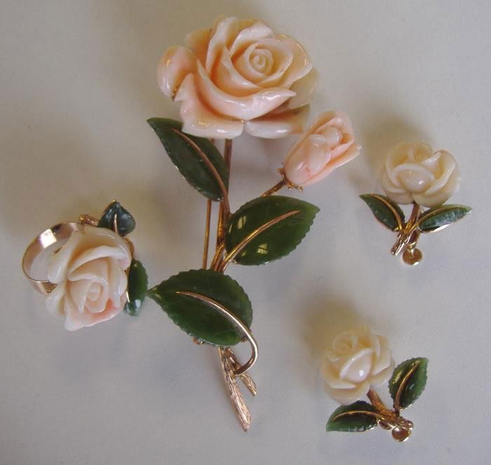 Light Pink Coral Brooch Ring & Earrings in 14K Gold: Carved light pink coral rose-formed brooch, ring and earrings with green glass leaves, all set in 14K gold. The brooch measures 4.25" long. Ring size 6.75. Screw-back earrings.