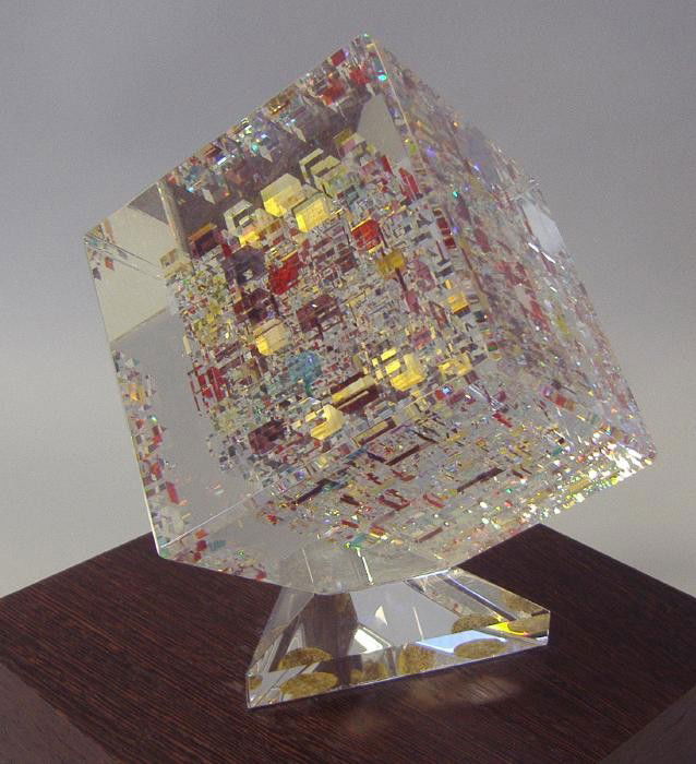 JON KUHN Glass Cube Sculpture, signed & dated: Jon Kuhn glass sculpture, signed, dated 1997 and titled "Goldberry". The overall height of the glass sculpture measures 7.5" high. The cube itself measures 4.25" square and is attached to a glass tria