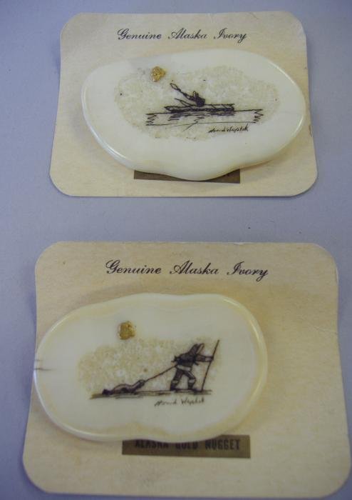 2 Alaskan Ivory Scrimshaw Gold Nugget Pins, Signed: Two Alaskan ivory scrimshaw brooch pins, each with a gold nugget. Measuring 1.25" x 2" and 1.5" x 2.25". Signed Howard Wephok.