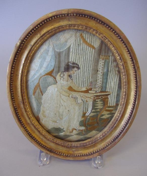 19thc English Needlework, Young Woman with Letter: Framed English needlework picture of a young woman with a letter in her hand, gazing at a photo of her lover. Framed measurement, 11" x 9".