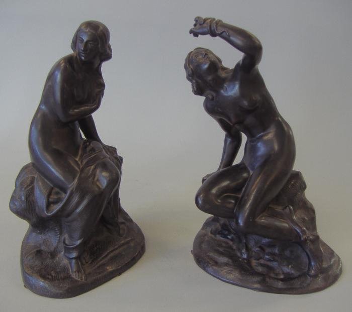 2 Russian Bronzed Iron Nude Females, Foundry Marks: Two Russian bronzed iron models of nude females sitting on rockery. Both with a foundry mark and writing in cyrillic on the underside interior. Overall height of each 10.75" tall. These are iron sculp