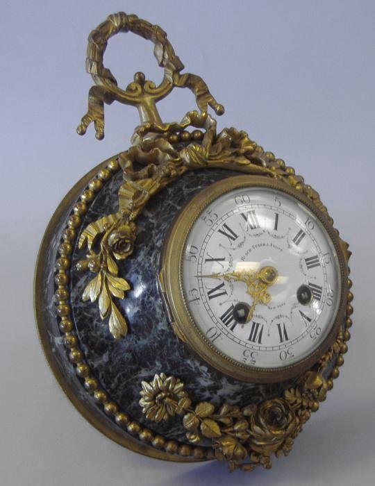 Black Starr & Frost Marble & Ormolu Table Clock: Louis XVI-style green marble & ormolu mounted wall or table clock with an easel backing. Retailed by Black Starr & Frost, New York. The clock measures 8" in diameter. Overall height to top of ormolu w