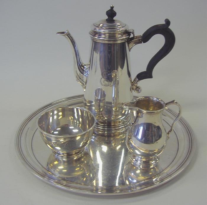 Tiffany & Co Sterling Tea Set with Tray 4-Pieces: Sterling 4-piece tea set by Tiffany & Co. Comprised of a tray, measuring 12" in diameter, teapot with black ebonized wood handle, cream jug and sugar bowl. All pieces with ED monogram. NOTE: slight be