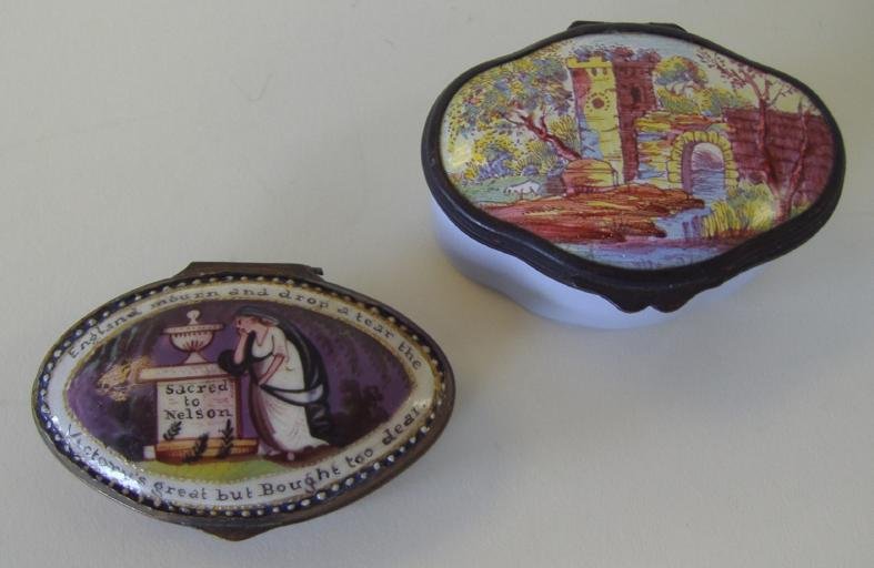 2 Porcelain & Enamel Snuff or Patch Boxes: Porcelain and enamel snuff box depicting a mourning scene at the grave of Admiral Lord Nelson, together with another patch box depicting a tower bridge within a river landscape setting. Measures 2.25"