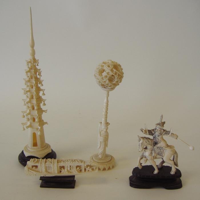 Chinese Carved Ivory Pagoda, Puzzle Ball, Boat +: Chinese carved ivory pagoda measuring 9" high (NOTE: missing three bells toward the bottom), together with a puzzle ball with carved stand measuring 6.75" high, a boat on stand, measuring 4" long, and