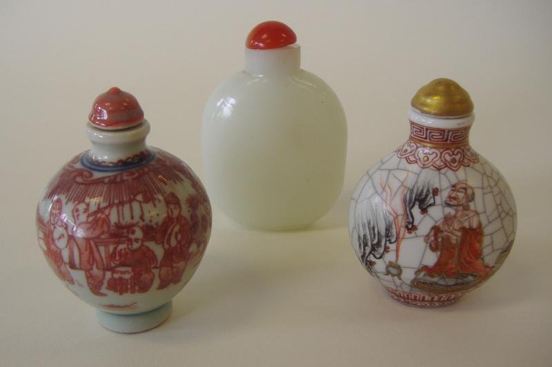 3 Chinese Snuff Bottles, Porcelain & Glass: Three Chinese snuff bottles comprised of two porcelain bottles, one with crackle-glaze. Both signed and measuring 2.5" high, together with a white Peking glass bottle measuring 2-7/8" high.