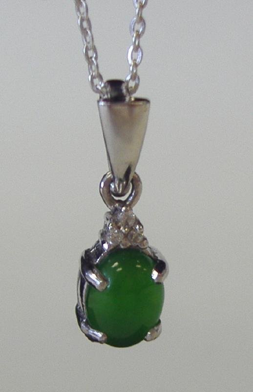 Chinese Jadeite Jade & Diamond 14K Gold Pendant: Chinese jadeite jade cabochon measuring 8mm x 6mm, set in a 14K white gold pendant with 3 diamonds. Sterling neck chain.