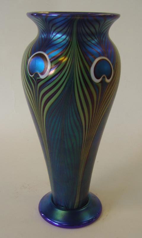 Beyers Orient & Flume Art Glass Vase: Orient and Flume art glass vase, designed by Scott Beyers. Blue iridescent peacock design. Signed underfoot and with label. Also included is the authentication registration tag. Measures 10.75" tall.