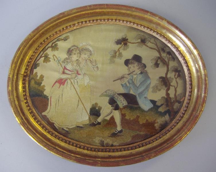 19thc English Needlework Musician & Young Girls: 19thc English framed oval needlework on silk of a young male musician serenading two young girls. Image measures 11" x 8.5". Framed measurement 11" x 14".