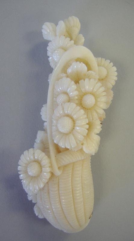 White Angel Skin Carved Coral Brooch Pin: White angel skin coral brooch pin. Intricate carving depicting a basket of flowers. Sterling silver backing. Measures 2-3/8" long and 7/8" wide.