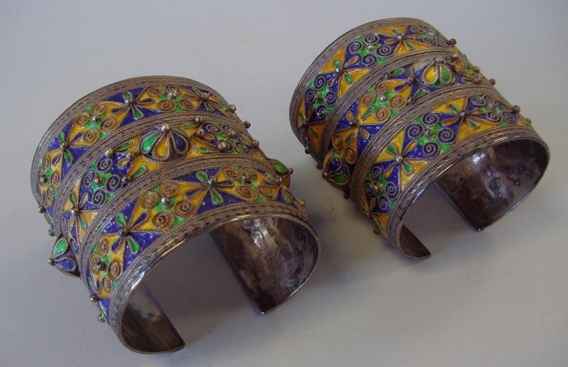 Persian Enamel & Silver Cuff Bracelets: Pair of antique Persian enamel and 900 silver cuff bracelets. Bead and wirework rosettes. Each cuff measuring 2.75" high and 3.5" wide.