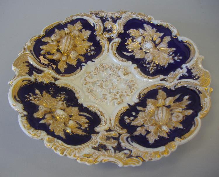 Meissen Porcelain Cobalt Dish, Raised Fruit Motif: Meissen porcelain shallow dish with raised leaf and fruit motif. Cobalt blue and gilt decorated. Measures 9" in diameter and 1.5" high. Signed with the cross swords mark underfoot.