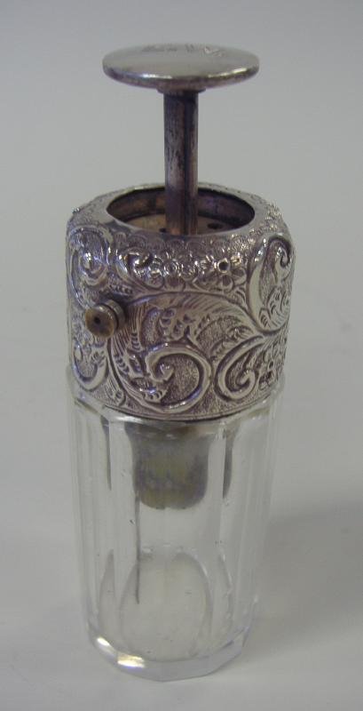 English Sterling & Glass Atomizer Perfume Bottle: English sterling silver and faceted glass atomizer perfume bottle. Sterling cap hallmarked for Chester, England, 1908. Initialed on the top E.W. Measures 4.5" high.