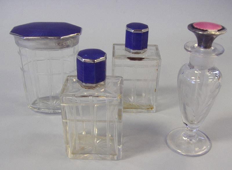 Art Deco Guilloche Enamel & Glass Perfume Bottles: Comprised of a pair of Art Deco etched glass perfume bottles and a powder jar, each with cobalt blue guilloche enamels and chrome lid caps. Together with a floral etched perfume bottle with a pink gui