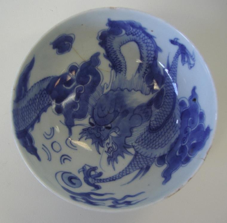 Yongzheng Chinese Porcelain Dragon Bowl: Chinese blue and white porcelain bowl. Yongzheng (1723-1735), 6-character mark underfoot. Dragon motif. Measures 4-5/8" in diameter and 2-1/8" high. NOTE: nicks to rim and hairlines. Provenance: Estat