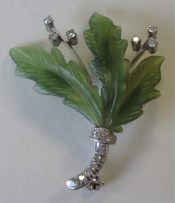 Diamond & Aventurine Brooch set in 14K White Gold: Diamond and aventurine brooch pin set in 14K white gold. Leaf formed aventurine with 6 round cut diamonds as buds. The stem set with 8 round cut diamonds. Measures 1.5" high and 1.25" wide.