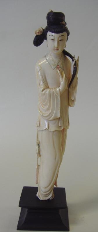 Chinese Carved Polychrome Ivory Female Figure: Well carved antique polychrome ivory figure of a standing female with comb in one hand and her braided hair in the other. Overall measurement on wood stand 12.25" high. NOTE: Ivory only shipped to a U
