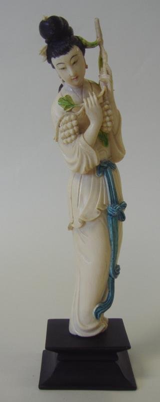 Chinese Carved Polychrome Ivory Female Figure: Well carved antique polychrome ivory figure of a standing female holding a leafy branch with grapes. Overall measurement on wood stand 11-7/8" high. NOTE: Ivory only shipped to a US address.