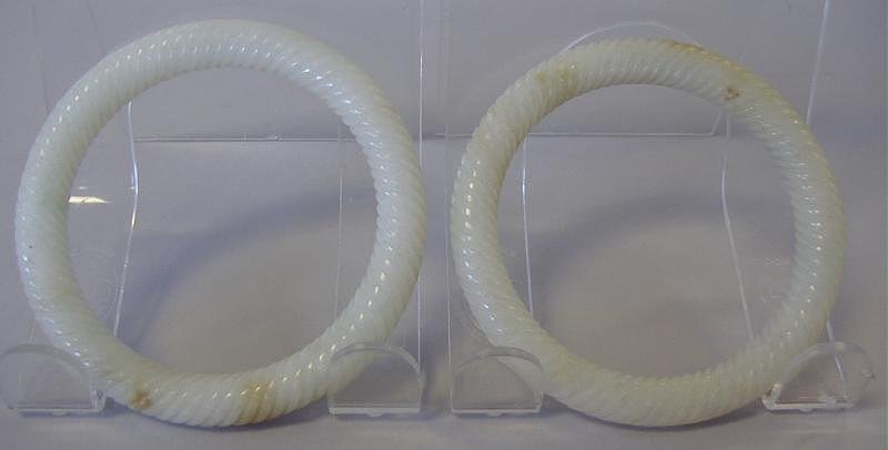 Chinese Carved White Jade Bangle Bracelets, Pair: Well carved pair of white jade bangle bracelets. Early 20th century. Each measuring 3-1/8" in diameter. Inside circumference 7.5".