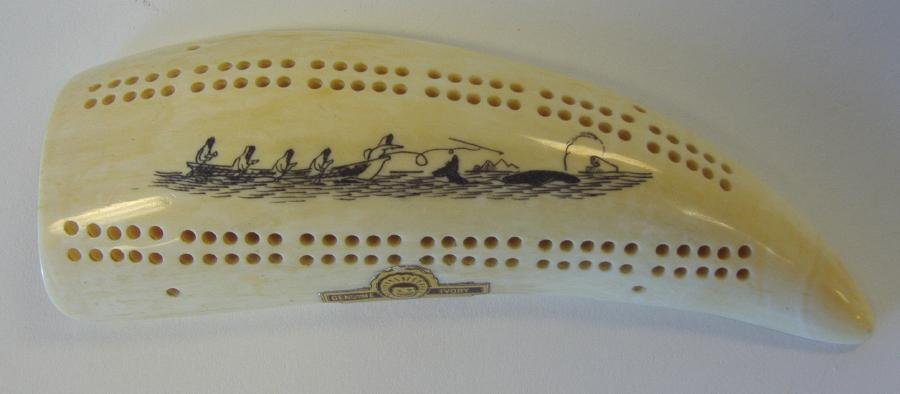 Alaska Inuit Ivory Scrimshaw Cribbage Board: Scrimshaw drawing of whalers at sea in pursuit. Measures 5.5" long and 1-7/8" wide.