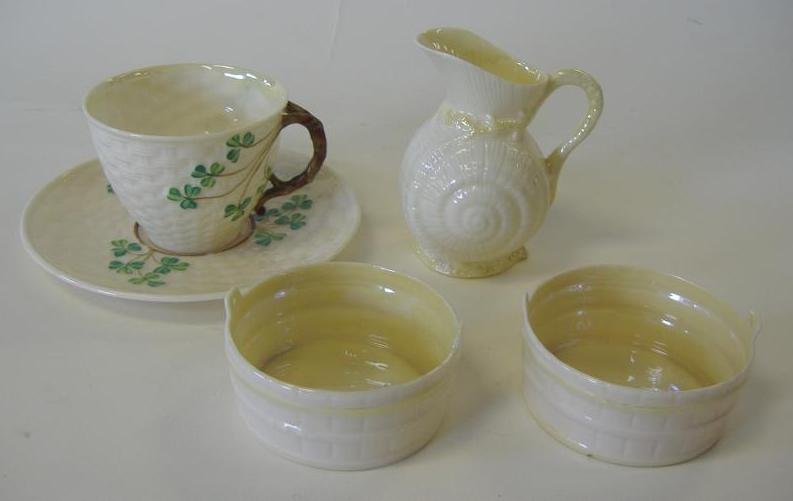 BELLEEK Black Mark Cup, Saucer, Jug & Bowls: Belleek clover cup and saucer, together with a cream jug measuring 3.5" high and two small bowls measuring 2-7/8" in diameter and 1.25" high. All with the black mark