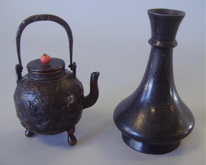 Asian Bronze Teapot and Bud Vase: Asian miniature bronze teapot with raised decoration depicting birds in flight among florals. Coral bead finial. Measures 4" high to top of handle and 2.75" wide from spout to end of handle. Together 