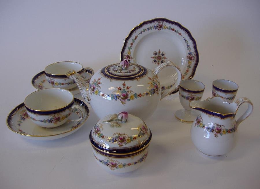 Meissen Porcelain 10 Piece Tea Service: Meissen porcelain tea service. Comprised of a teapot, cream pitcher, covered sugar bowl, 2 cups with under-plates, 2 egg cups and 1 cookie plate measuring 6.25" in diameter. The teapot measures 4.5" t