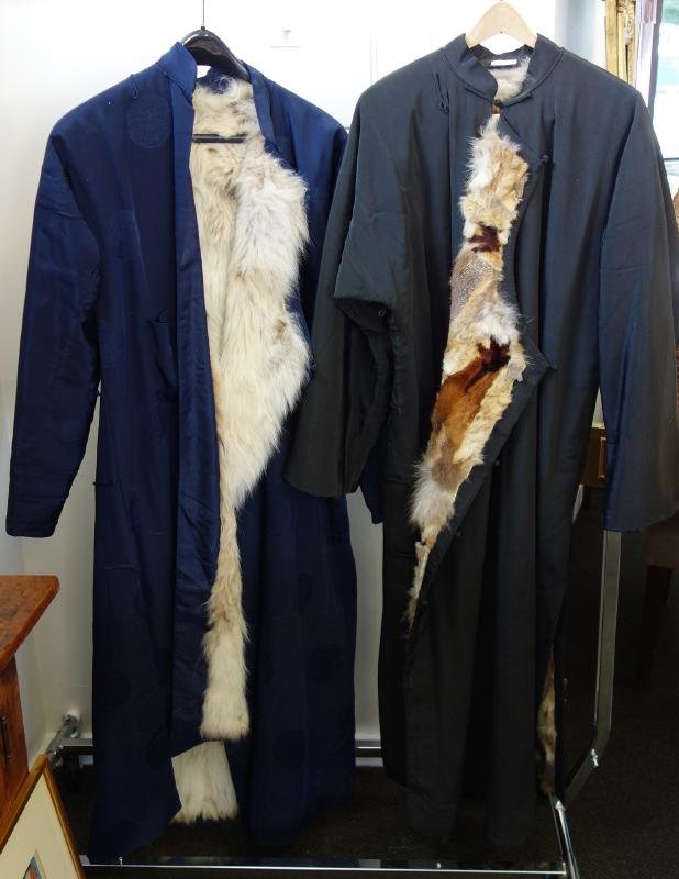 2 Chinese Fox Fur Men's Scholar's Long Coats: 2 Chinese men's long gowns. c.1920s. Fur lined Scholar's coats. Black coat with "fox paw" fur lining. Together with a blue brocade coat with fox lining. Each measuring approximately 53" long and 23" w