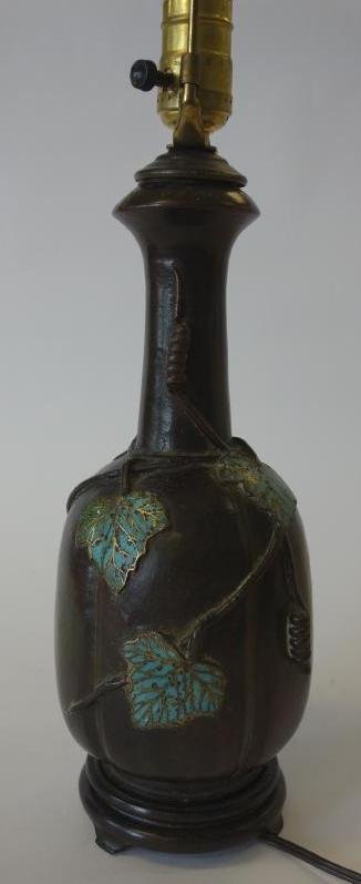 Bronzed & Enameled Gourd Formed Lamp: Bronzed metal lamp. Gourd formed with enameled leaves. Linen shade. Mounted on a wood base. Measures 23" high to top of finial.