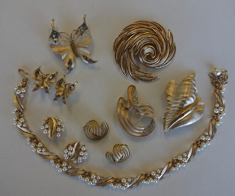 Trifari Necklace, Earrings & Brooch Pins: Trifari jewelry. Comprised of a leaf-formed necklace, with matching earrings, a butterfly brooch with matching earrings, freeform pin and earring set, a shell formed brooch and a large freeform brooch