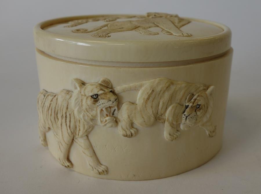 Carved African Ivory Box, Lions & Tigers: Carved African ivory oval box. Elephant tusk carving with raised in relief carvings of lions and tigers on the lid and sides. Measures 4-1/8" x 3.5" x 2.5" high. NOTE: ill fitting lid and bottom piece