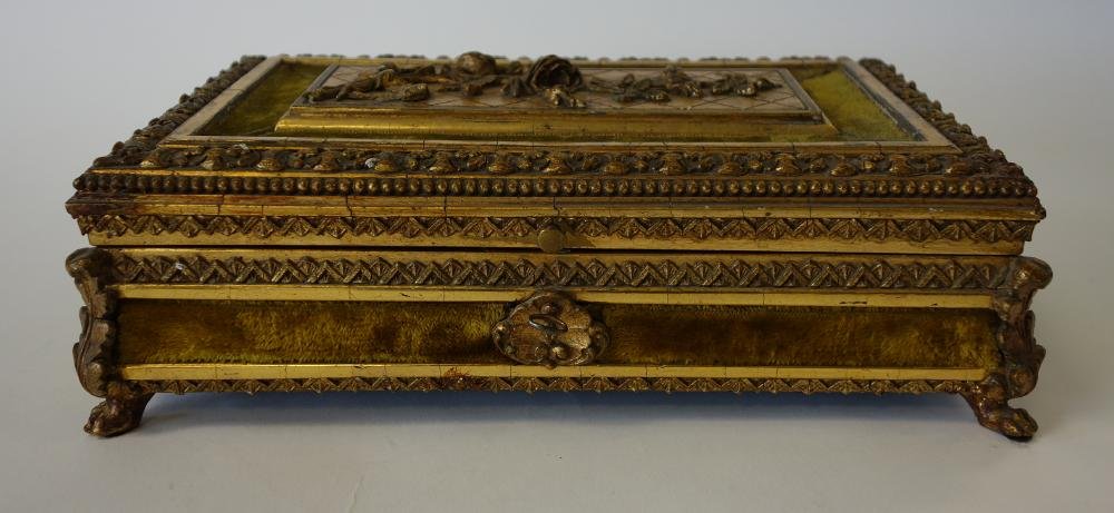 Carved Gilt Wood Jewel Casket Box: Carved gilt wood and velvet jewel casket or jewelry box. Late 19th/early 20th century. Ornately carved with raised florals on lid, acanthus leaf and paw feet. Silk lined interior. Lock and key. Measur