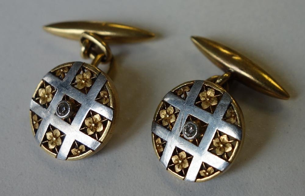 14K Gold & Diamond Cufflinks: A pair of 14K (acid tested) yellow and white gold cuff links. Center diamond surrounded by white gold horizontal and vertical bands encasing a floral motif. Measuring 1/2" in diameter. Overall weight 